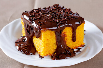 Slice of carrot cake with chocolate frosting on a ceramic plate. homemade Brazilian dessert