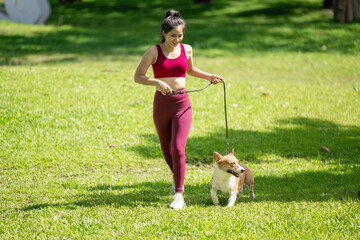 A woman is walking her dog in a park