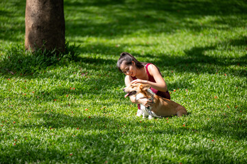 A woman is petting a dog in a park
