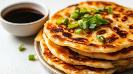 Golden Brown Pancakes with Green Onion Garnish Served with Sauce