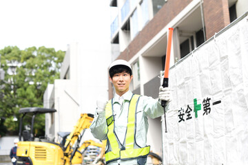 建設現場でガッツポーズをする交通誘導員