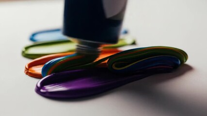 Purple paint pouring from tube alongside colorful paints, vibrant art concept. - Powered by Adobe