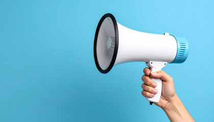 Amplified Announcement: A hand firmly grasps a sleek megaphone against a vibrant blue backdrop, ready to project a message clearly. 