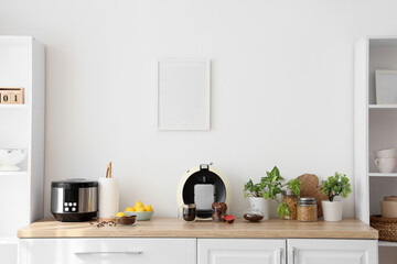 Modern coffee machine with capsules and beans on counter in kitchen interior