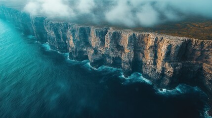 Majestic Cliffs Meet Turquoise Ocean Under Misty Sky
