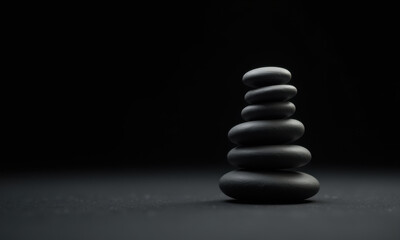 Fototapeta premium Zen Balance: Stacked Pebbles on Dark Background