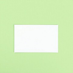 Fototapeta premium Blank white paper centered on a soft green background