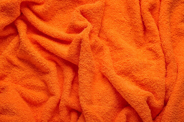 Texture of orange terry fabric as background, closeup