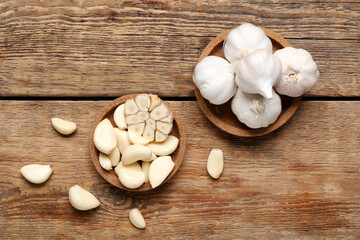Bowl with fresh garlics on wooden background