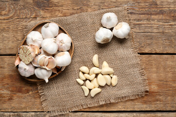 Plate with fresh garlics and cloves on wooden background