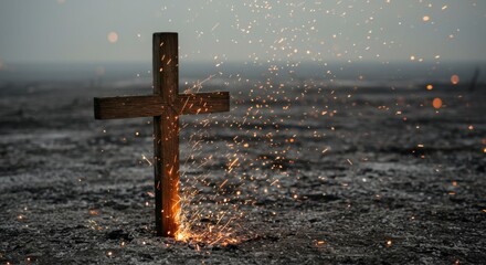 A wooden cross stands amidst charred earth, with sparks and embers