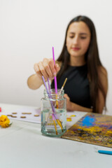 Focused artist cleaning brushes during a creative session