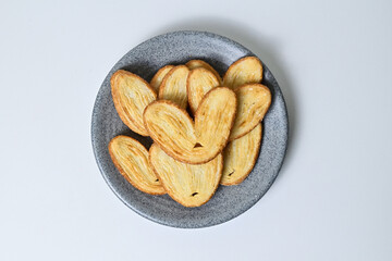 Top view of many mini pies on grey or gray plate isolated on white background. Clipping path. Love sign. High angle, above, Close up. Danish. Pastry. Butter. Heart.