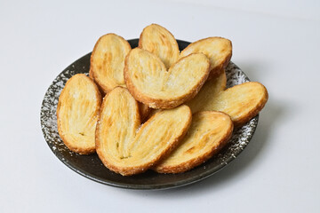 Close up view of many mini pies on black And white plate isolated on white. background. Clipping path. Love sign. High angle, above, Close up. Butter. Danish. Pastry. Heart.