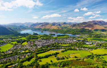 S.W. over Keswick town and Derwentwater to Cat Bells and Newlands in the Lake District. Rust winter bracken still covers fells in May. Early morning