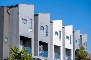 Contemporary townhouse complex with a minimalist façade design, with private balconies in suburban Melbourne, Australia. Modern medium-density urban housing.