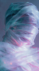 Obraz premium Surreal image of figure wrapped in translucent fabric with colorful lighting