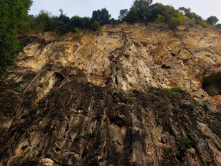 Explore the rugged beauty of rocky cliffs adorned with resilient trees and lush plants. These natural formations are a testament to the power of geology and erosion, creating breathtaking landscapes.