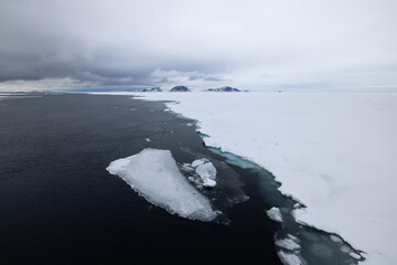 Floating ice on the ocean with mountains in the background in the arctic of Svalbard, Norway © Reto Ammann