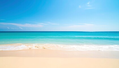 Obraz premium Serene beach scene; soft, blurred turquoise water meets pale sand under a bright blue sky