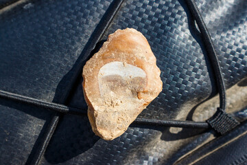 A small flint scraper found in a field, archaeological find of the Stone Age