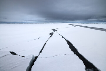 Ice cracks in floating ice on the ocean with mountains in the background in the arctic of Svalbard, Norway © Reto Ammann