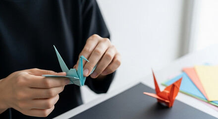 Hands Delicately Folding a Blue Origami Crane, Paper Craft Art