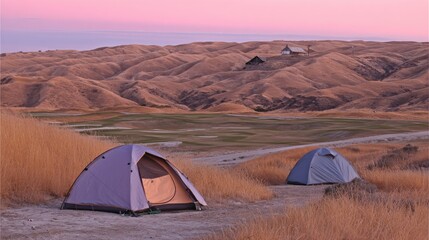 Gray tent pitched on a hill overlooking a golf course.