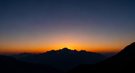 Obraz premium Vibrant Mountain Silhouette at Sunset: Golden Hour Peaks Against Twilight Sky