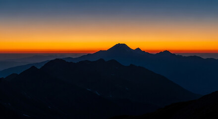 Fototapeta premium Vibrant Dawn Sky Over Silhouetted Mountain Peaks: Tranquil Alpine Landscape