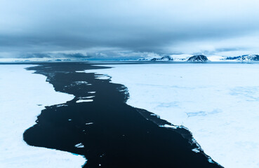 Floating ice on the ocean with mountains in the background in the arctic of Svalbard, Norway © Reto Ammann