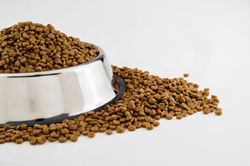 Dog and cat dry food on a stainless steel bowl on a white background
