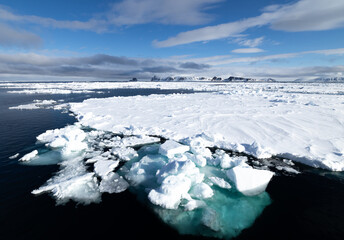 Floating ice on the ocean with mountains in the background in the arctic of Svalbard, Norway © Reto Ammann