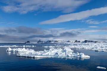 Floating ice on the ocean with mountains in the background in the arctic of Svalbard, Norway © Reto Ammann
