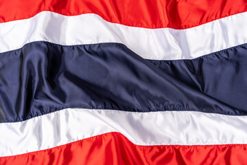 Thai flag in fabric pattern sewn together with a seam. Background Wallpaper of Thailand flag waving in wind.