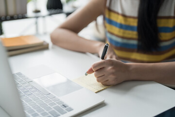 Online Tutoring Asian Girl in Headphones Engaged in Online Class with Laptop education writing homework study e-learning preparing for exam