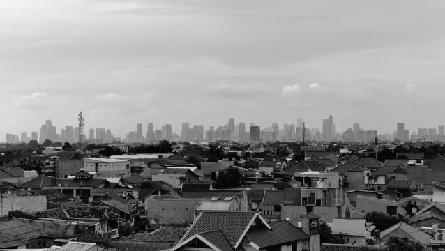 view from the parking lot showing tall buildings in the distance, black and white photo