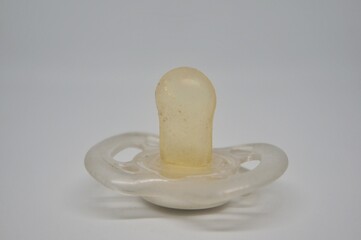 Broken baby pacifier with rubber nipple on white background