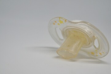 Broken baby pacifier with rubber nipple on white background