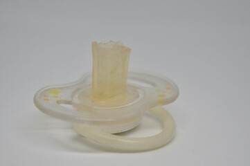 Broken baby pacifier with rubber nipple on white background