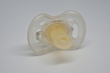Broken baby pacifier with rubber nipple on white background
