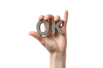 Hand holding textured stone letters forming the word O K isolated on a transparent background image