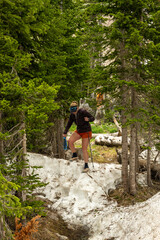 Woman In Shorts Climbs Down Snow Bank In Rocky Mountain
