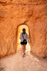 Woman With Camera Walks Through Hoodoo Tunnel