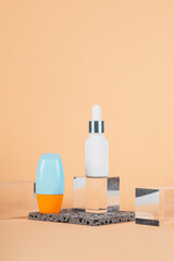 Cosmetic product in tube, bottle, lotion or serum with stylish props on cream background. 