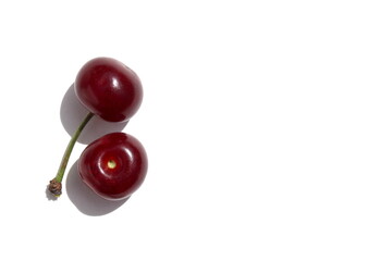 There are two ripe cherries on a white background.	
