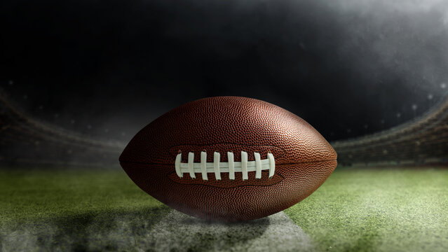 American football ball on the green field of an American football stadium. Concept of sport - Powered by Adobe