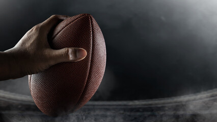American football player holding the ball during the game in an American football stadium. Concept of sport