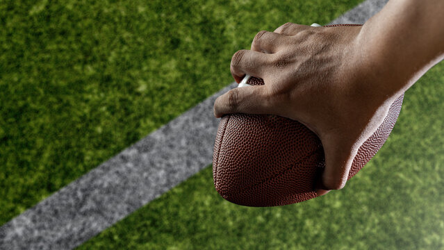 American football player holding the ball during the game in an American football stadium. Concept of sport