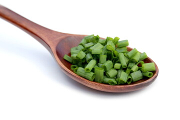 On a white background lies a wooden spoon with chopped onions.